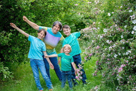 Grandmother and grandchildren, playing together in the park, springtimeの写真素材