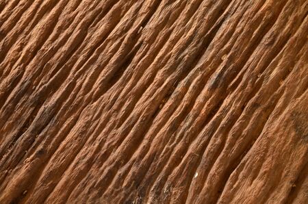 Old rough wood surface is pitted with cracks.