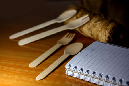 Spoons, forks, made of wood on a wooden background. Blank notebook mock up ,Template for advertising or brandingの写真素材