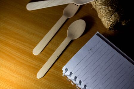 Spoons, forks, made of wood on a wooden background. Blank notebook mock up ,Template for advertising or brandingの写真素材