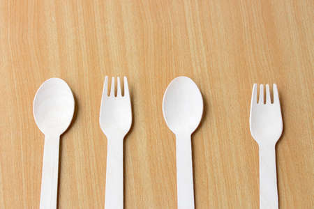 Spoons, forks, made of wood on a wooden background.の写真素材