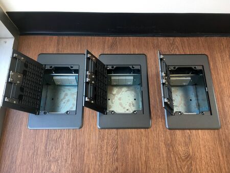 Floor plug,pop up plug in metal cover installed in wooden floor.Electrical work.System engineering.