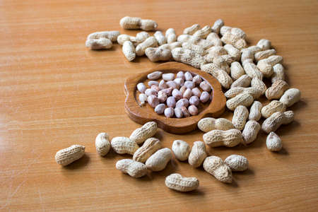Peanuts in shells on wood background