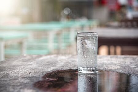 Glass of water placed on a wooden table, selective focus, blur some part.の写真素材