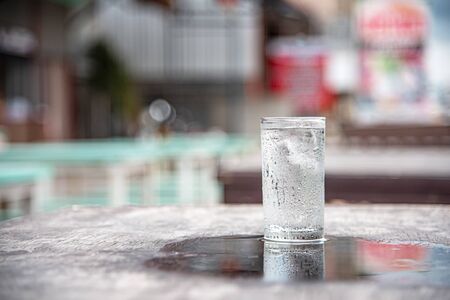 Glass of water placed on a wooden table, selective focus, blur some part.の写真素材