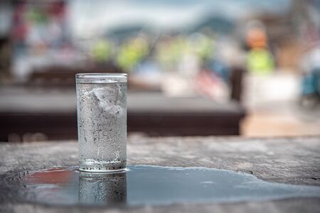 Glass of water placed on a wooden table, selective focus, blur some part.の写真素材