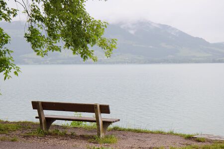Scenic landscape with a bench by a lake in Aistrian alpsの写真素材