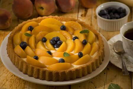 whole peach flan with blueberriesの写真素材