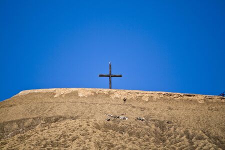 A Christian cross on an artificial mountain where mining is operated in Hesse, Germanyの写真素材