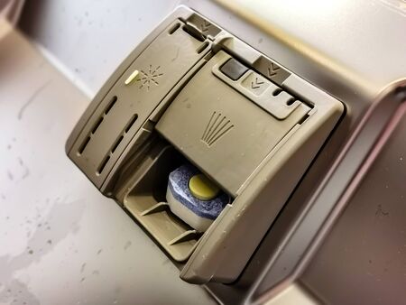 putting soap tablet in dishwasher machine, close up. Kitchen domestic appliance conceptの写真素材