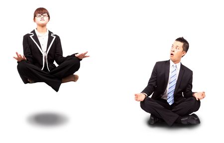 businesswoman and businessman in yoga lotus-pose and relaxing. Surprised man watching woman Floating in the airの写真素材