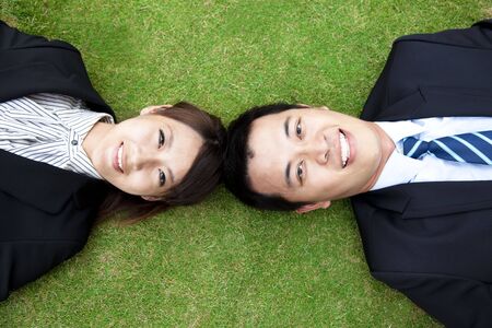 business couple.happy  businessman and woman Lay on the grass