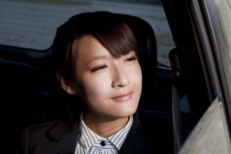 beautiful business woman sitting in the car and looking out car window