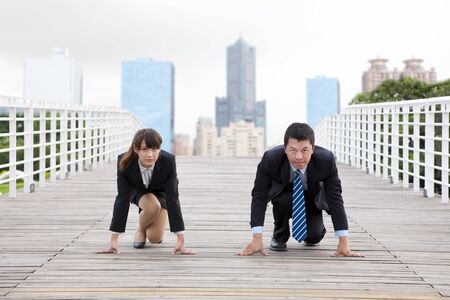 Business man and woman  getting ready for race in business の写真素材