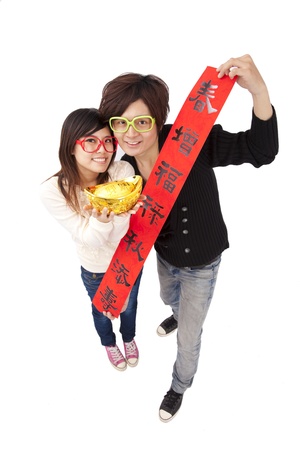 Happy chinese new year. Young couple holding gold ingot and red spring coupletsの写真素材