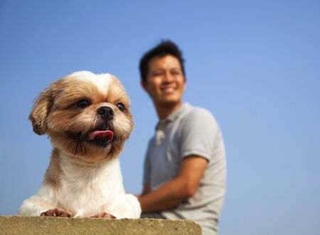 Young man sitting with  his dogの写真素材