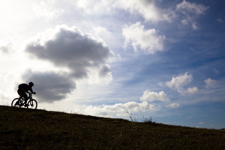  silhouette of a mountain biker on an cloud background  の写真素材