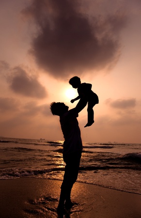the silhouette of happy father and little girl on the beachの写真素材