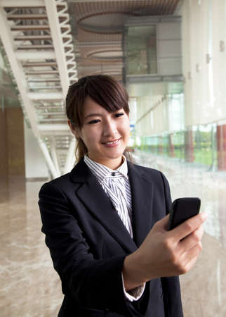 young businesswoman watching smart phone in handの写真素材