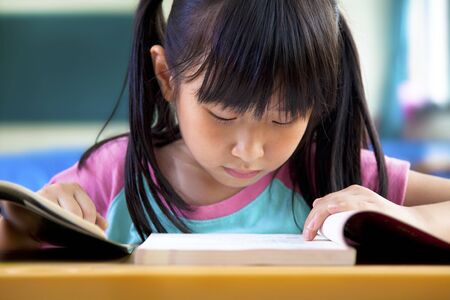 little girl studying in classroom at schoolの写真素材