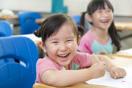 happy little girls in the classroomの写真素材