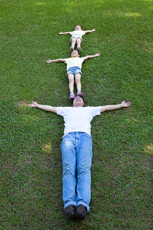 happy family lying on the grassの写真素材