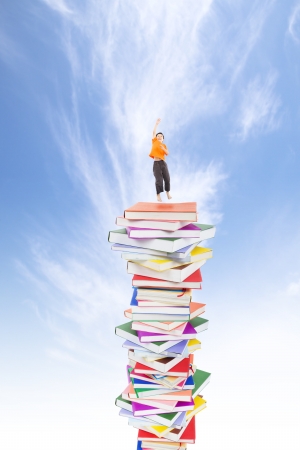 happy kid jumping on the booksの写真素材