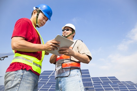  two workers  discussing with tablet pc before  solar power stationの写真素材