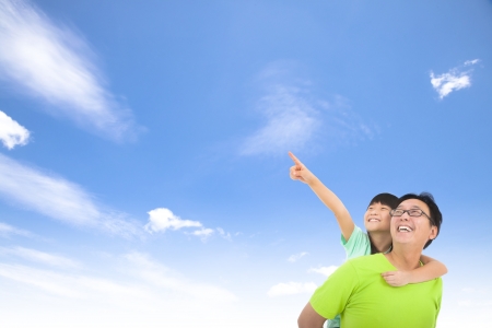 Happy family looking and pointing with cloud backgroundの写真素材