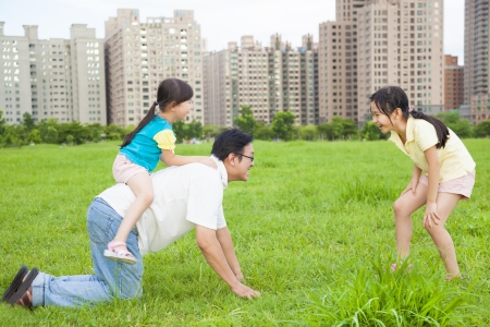 happy  father playing with daughters in the city parkの写真素材