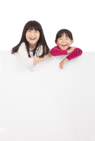 happy little girls showing blank board on a white backgroundの写真素材