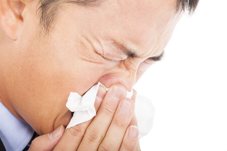 young man is sneezing with toilet paperの写真素材