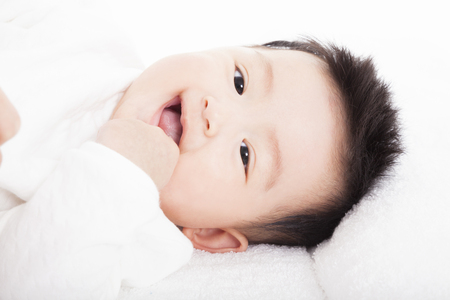 Baby having laughing and lying  on the towelの写真素材