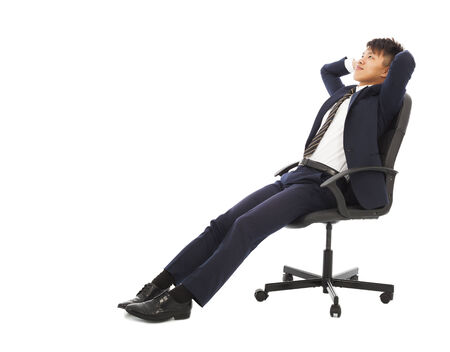 businessman sitting on a chair and holding headの写真素材