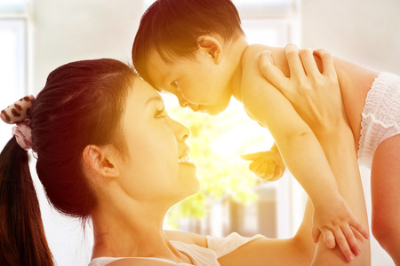 Happy  mother holding adorable child baby with sunrise backgroundの写真素材