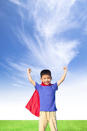 happy little boy imitate super hero and open arms with blue skyの写真素材