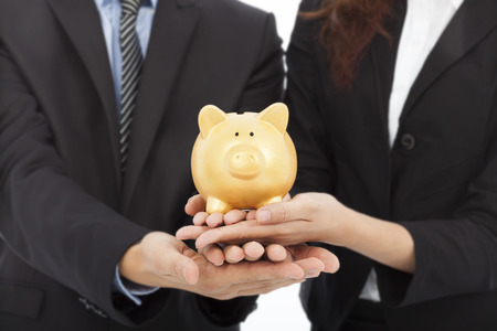 hands of business people holding a piggy bank .financial or saving concept over with の写真素材
