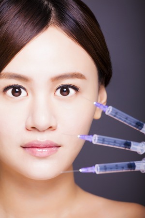 asian beautiful woman gets injection in her face.の写真素材