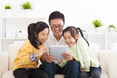 happy father using tablet pc with little girlsの写真素材