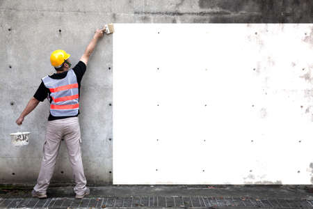 worker painting the old wall in whiteの写真素材