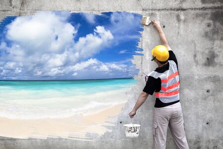 worker with paint brushes drawing summer beach on the wallの写真素材