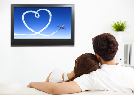 young couple watching the  tv show in living room
