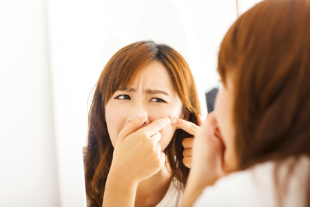 Young  woman with pimple on her faceの写真素材