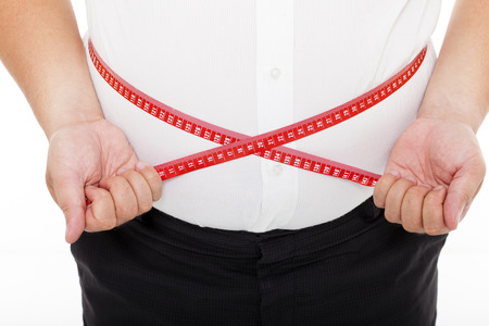 Fat man holding a measurement tapeの写真素材