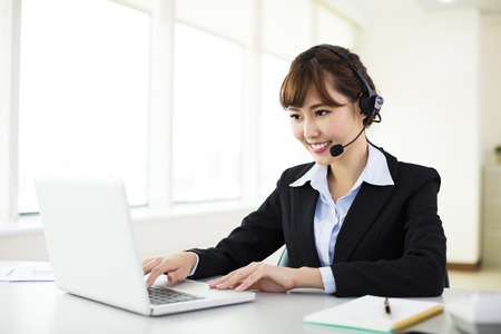 young beautiful  businesswoman with headset in officeの写真素材