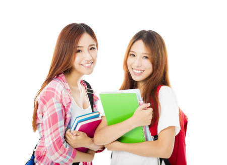 Two  happy teenage students girls isolated on whiteの写真素材