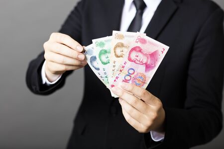 businessman holding yuan RMB in his handsの写真素材