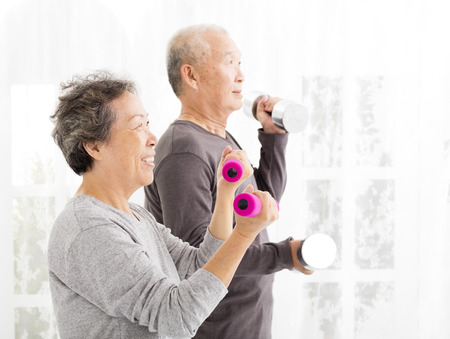 happy senior couple exercising with dumbbellsの写真素材