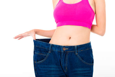 beautiful slim young woman with big jeansの写真素材