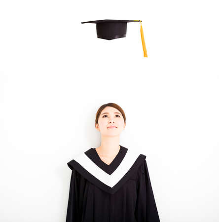happy female graduate looking the graduation cap in air